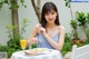 A woman sitting at a table with a plate of food and a glass of orange juice.