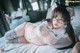 A woman laying on top of a bed wearing glasses.