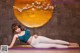 A woman in a blue top and white leggings doing yoga.